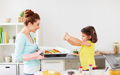 Image showing mother and daughter baking muffins at home