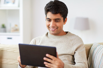 Image showing smiling man with tablet pc at home