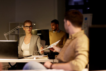 Image showing coworkers with papers working late at office