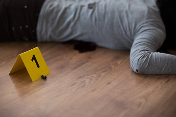 Image showing bullet and dead woman body on floor at crime scene