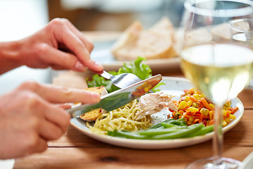 Image showing hands of woman eating pasta with chicken meat