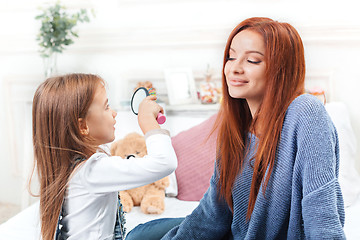 Image showing A little cute girl enjoying, playing and creating with toy with mother