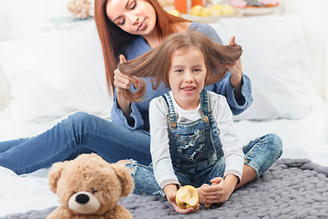 Image showing A little cute girl enjoying, playing and creating with toy with mother