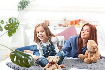 Image showing A little cute girl enjoying, playing and creating with toy with mother