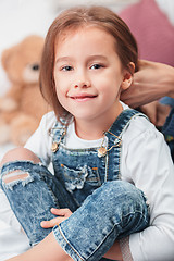 Image showing A little cute girl enjoying, playing and creating with mother hands