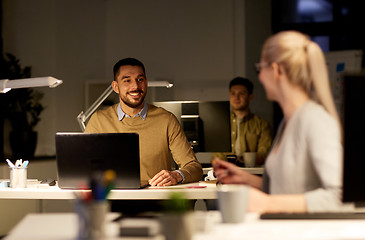 Image showing coworkers with laptop working late at office