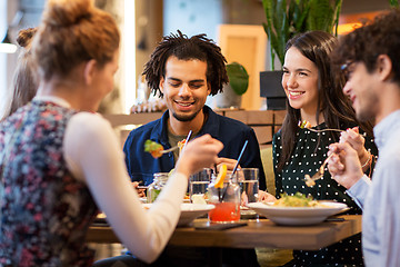 Image showing happy friends eating at restaurant