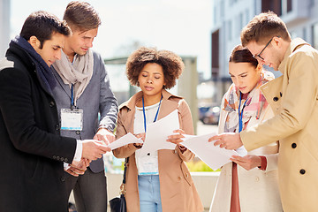 Image showing international business team with papers outdoors