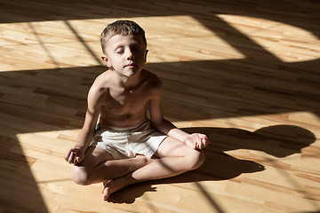 Image showing Charming little boy is while doing yoga at home