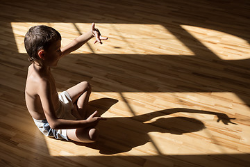 Image showing Charming little boy  playing  in theatre of shadows 