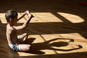 Image showing Charming little boy  playing  in theatre of shadows