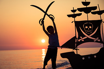 Image showing One happy little boy playing on the beach at the sunset time.