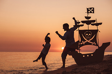 Image showing Father and son  playing on the beach at the sunset time.