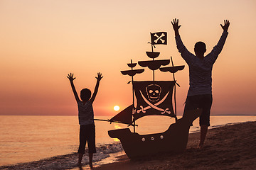 Image showing Father and son  playing on the beach at the sunset time.