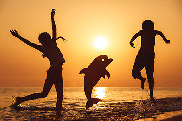 Image showing Happy children playing on the beach at the sunset time.