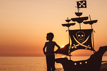 Image showing One happy little boy playing on the beach at the sunset time.