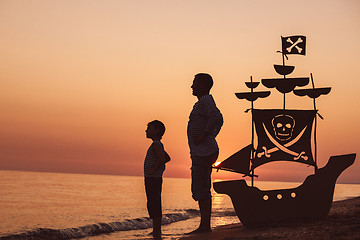 Image showing Father and son  playing on the beach at the sunset time.