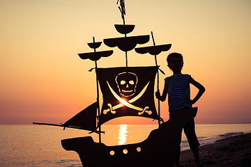 Image showing One happy little boy playing on the beach at the sunset time.