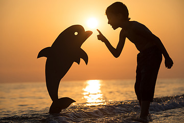 Image showing One happy little boy playing on the beach at the sunset time.