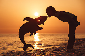 Image showing One happy little girl playing on the beach at the sunset time.