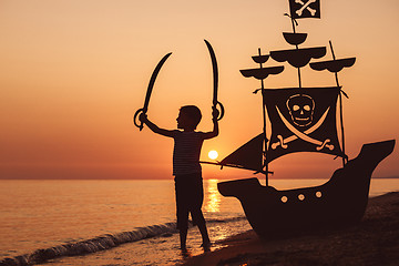 Image showing One happy little boy playing on the beach at the sunset time.