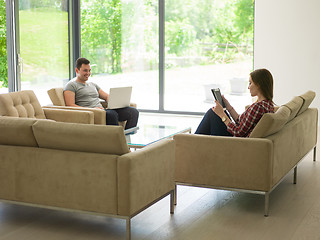 Image showing couple relaxing at  home with tablet and laptop computers