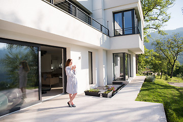 Image showing woman in a bathrobe enjoying morning coffee