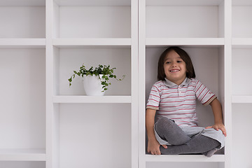 Image showing young boy posing on a shelf