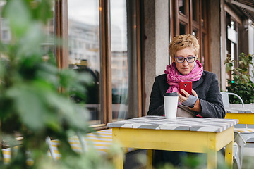 Image showing Woman with drink and smartphone