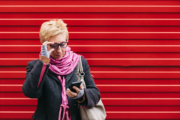 Image showing Adult woman with smartphone on street