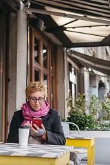 Image showing Woman with drink and smartphone