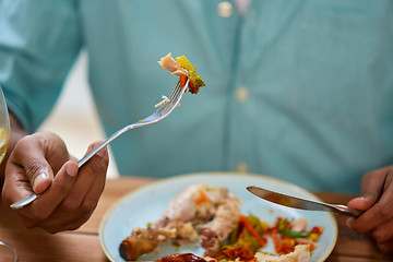 Image showing close up of man eating with fork and knife