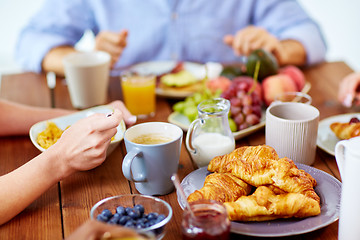 Image showing close up of people eating food at table