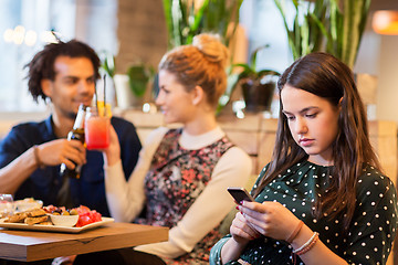 Image showing woman with smartphone and friends at restaurant