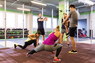 Image showing group of happy friends stretching in gym