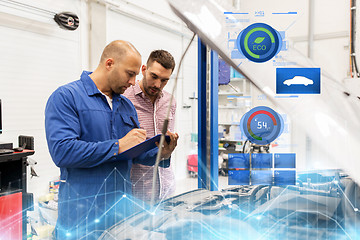 Image showing auto mechanic with clipboard and man at car shop