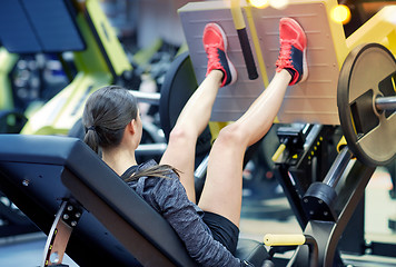 Image showing woman flexing muscles on leg press machine in gym