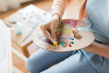 Image showing artist applying paint to palette at art studio