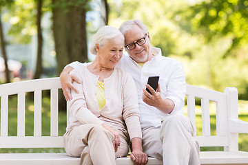Image showing happy senior couple with smartphone at park