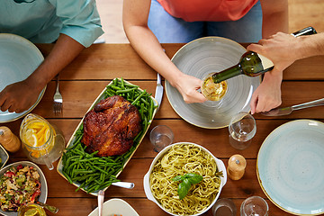 Image showing group of people eating and drinking wine