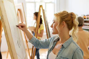 Image showing woman with easel drawing at art school studio