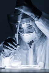 Image showing Life scientist researching in bio hazard laboratory. High degree of protection work.