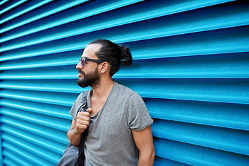 Image showing man in sunglasses with bag standing at street wall