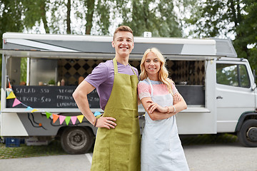 Image showing happy couple of young sellers at food truck