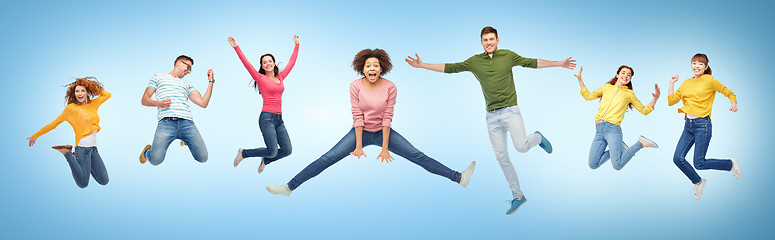 Image showing happy people or friends jumping in air over blue