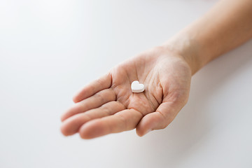 Image showing close up of hand holding medicine heart pill