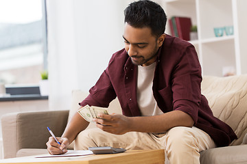 Image showing man with money and calculator filling papers