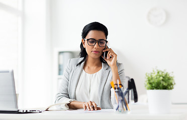 Image showing businesswoman calling on smartphone at office