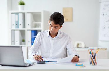 Image showing businessman with papers and calculator at office