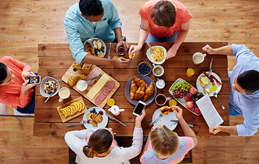 Image showing people with smartphones eating food at table